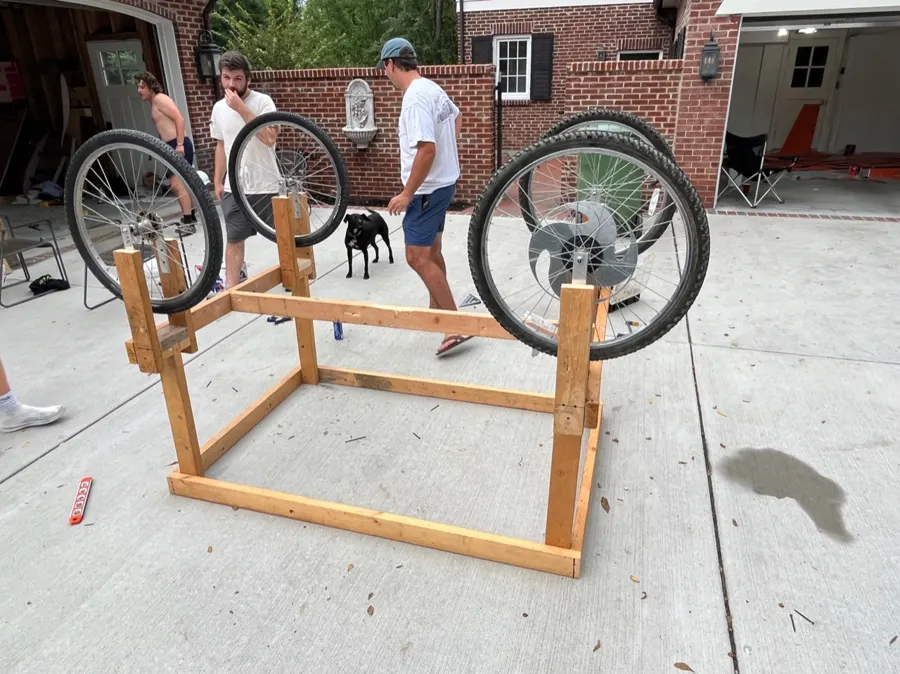 Wooden cart frame with four bike wheels attached.