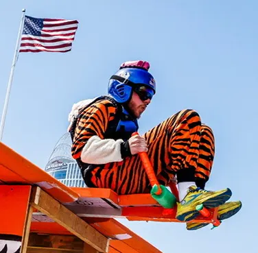 Pilot in a tiger costume gripping the handlebar during takeoff.