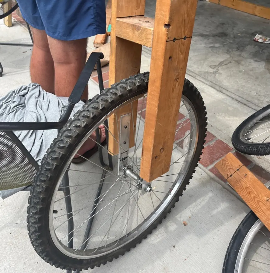 Bike wheel mounted in a wooden bracket.