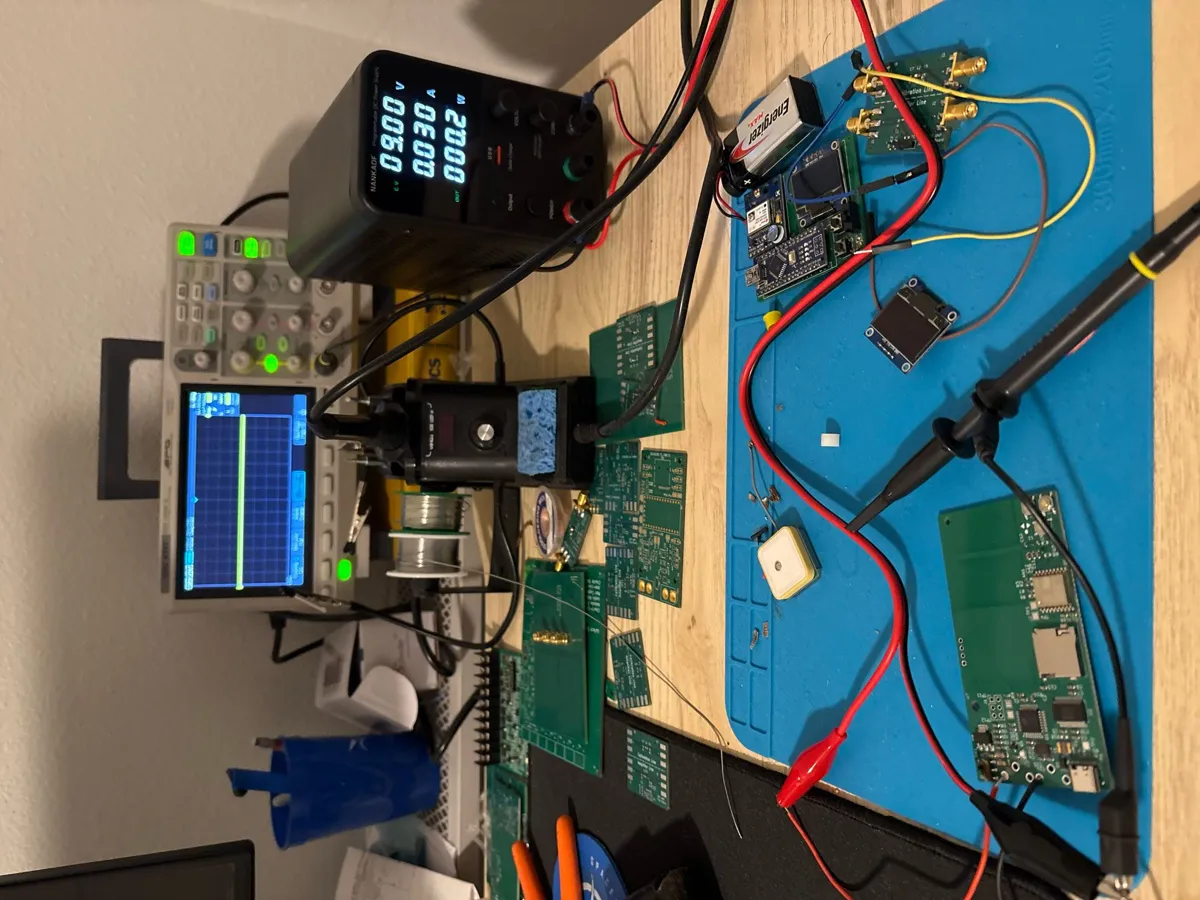 Electronics bench with a power supply, oscilloscope, probes and several boards during bring-up.